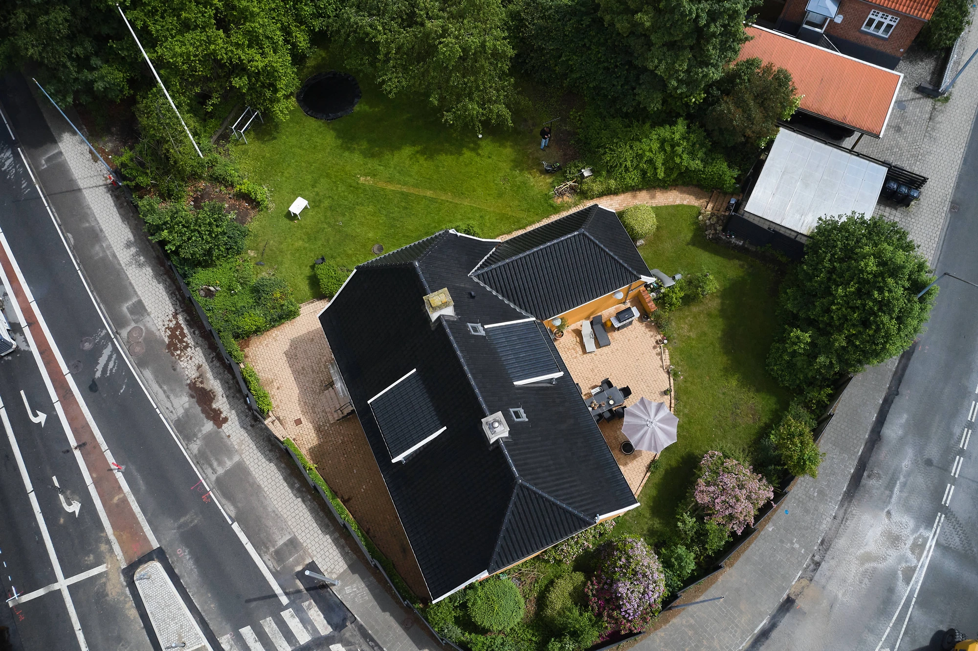 Luftfoto af det sorte tegltag med kvist, skorstene og ovenlysvinduer