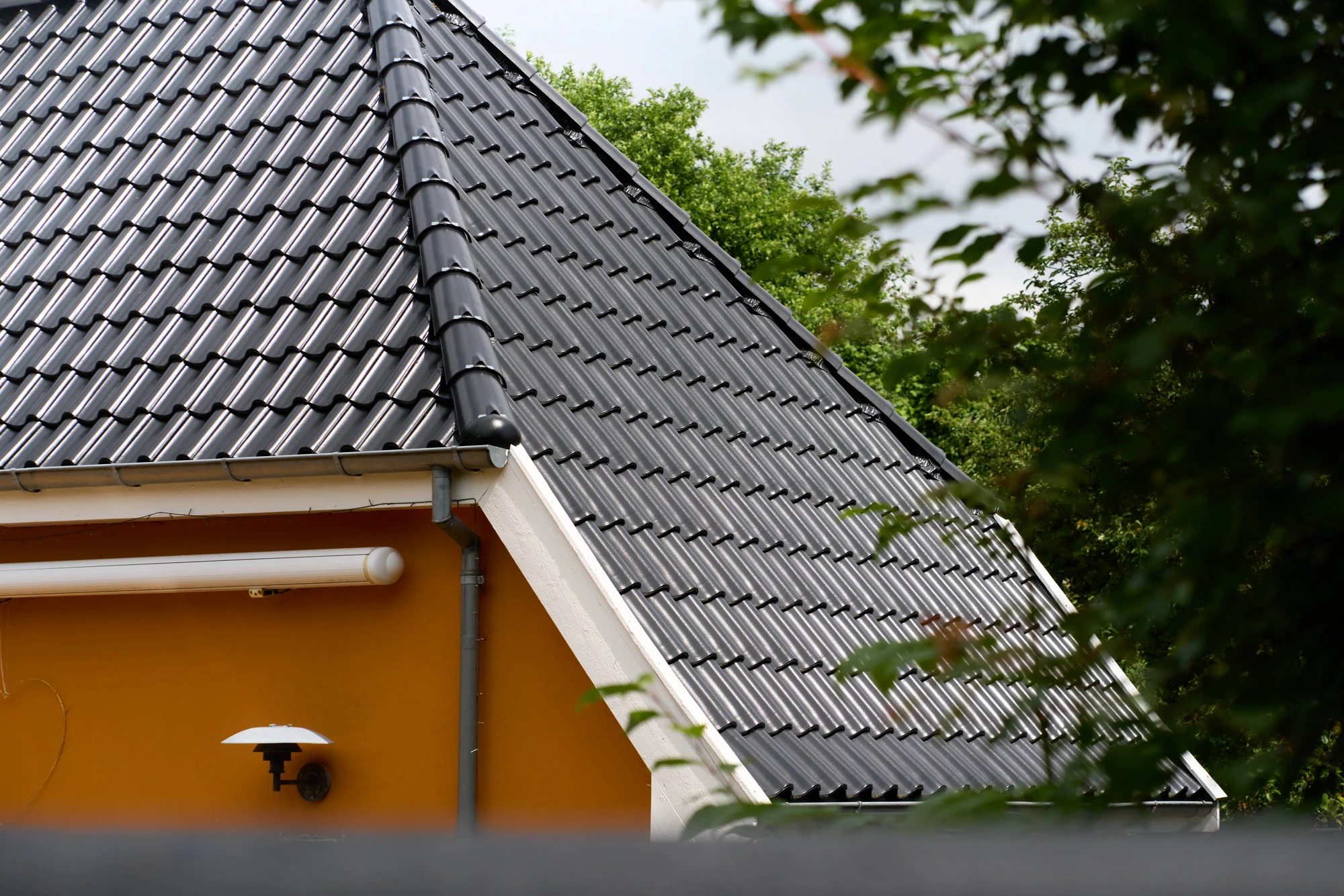 Nærbillede af de sorte, engoberede vingetegl og zinkinddækning
