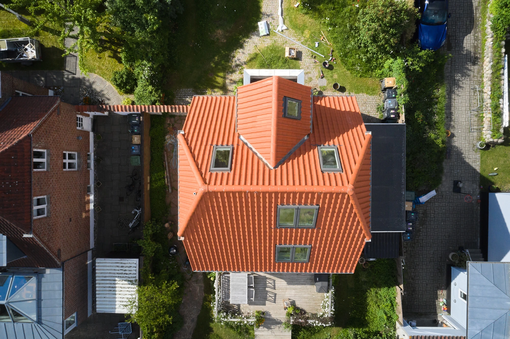Detalje af kvist med murstensgavl og relief under det røde tegltag